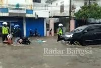 Anggota Satlantas Polres Sumenep Atur Lulu Lintas saat Banjir di Jalan Trunojoyo Sumenep.