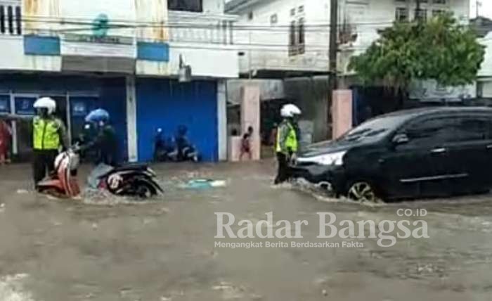 Anggota Satlantas Polres Sumenep Atur Lulu Lintas saat Banjir di Jalan Trunojoyo Sumenep.