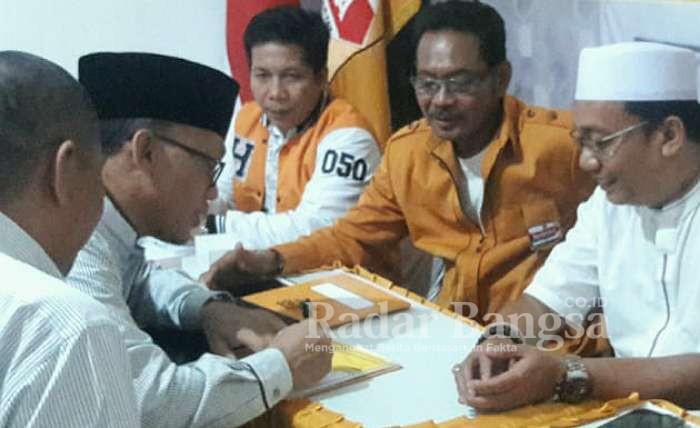 (kanan) Ismail Nachu mengambil berkas atau formulir pendaftaran penjaringan ke kantor DPC Hanura Kota Pasuruan pada Rabu (25/12) 