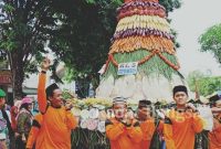 Ratusan masyarakat tumpah ruah ke jalan ikut mengarak tumpeng raksasa yang terdiri atas berbagai macam hasil bumi, Sabtu (28/12/2019)