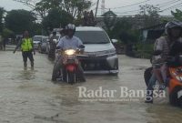 Tampak Anggota Kepolisian memberikan arahan pengguna jalan