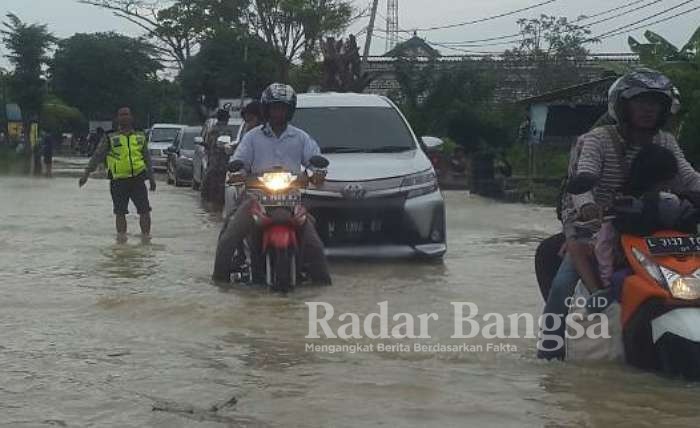 Tampak Anggota Kepolisian memberikan arahan pengguna jalan