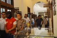 Kaos Merah tersangka saat di kawal petugas kepolisian