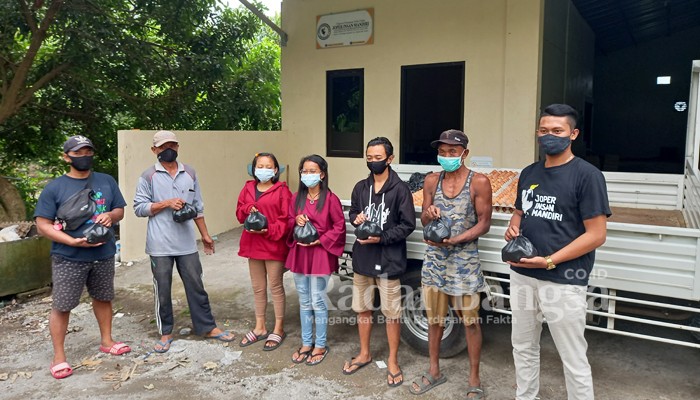 Aditya Bima, Kepala Kandang Ayam Petelur KPSU Joper Insan Mandiri Desa Pule (berkaos hitam) bersama warga penerima bantuan telur