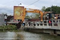 Jembatan Kiringan  nampak alat berat untuk membersihkan eceng gondok [IST]