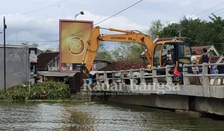 Jembatan Kiringan  nampak alat berat untuk membersihkan eceng gondok [IST]