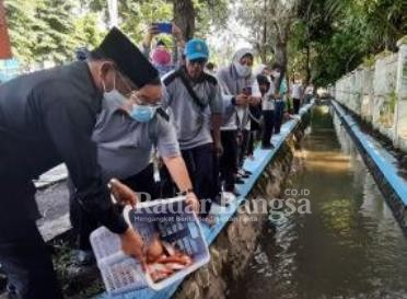  Pj Bupati Sidoarjo, Dr H Hudiyono, M.Si menebar benih ikan di sungai kecil barat Pendopo Delta Wibawa [HMS]