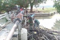  Koramil 0812/01 Kota jajaran Kodim 0812 Lamongan bersama warga  bersihkan tumpukan sampah di bendungan Dam pintu air kali Plalangan yang berada di desa Plosowahyu [IST]