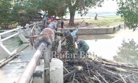  Koramil 0812/01 Kota jajaran Kodim 0812 Lamongan bersama warga  bersihkan tumpukan sampah di bendungan Dam pintu air kali Plalangan yang berada di desa Plosowahyu [IST]