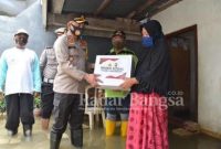 Kapolres Lamongan AKBP Miko Indrayana, S.I.K. saat memberikan bantuhan kepada korban banjir di Desa Sooko Kecamatan Glagah [IST]