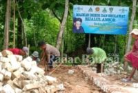 engah kaos coklat; Abu Hanif Saat Membantu Mengerjakan Pembangunan   Gedung Sekretariat PR GP Ansor 3 Desa di Kecamatan Ambunten Kabupaten Sumenep Jawa Timur. [Foto : Nrsmbr/Ong]