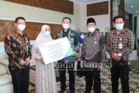 Bupati Lamongan Yuhronur Efendi serahkan santunan kepada ahli waris peserta BPJS Ketenagakerjaan yang mengalami kecelakaan kerja atau kematian di Ruang Kerja Bupati Pemkab Lamongan, Kamis (25/03/2021) [IST]