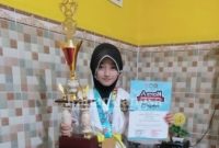 Widya Nur Hidayatul Ma'rifah atlit Taekwondo saat menunjukan medali emas dan piagam penghargaan, Selasa (09/03) [IST]