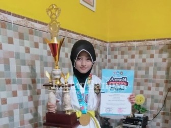 Widya Nur Hidayatul Ma'rifah atlit Taekwondo saat menunjukan medali emas dan piagam penghargaan, Selasa (09/03) [IST]