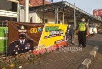 Petugas Kepolisian saat memasang himbuan larangan mudik [IST]