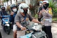 Kasatlantas AKP Indah Citra Fitriani saat memberikan hadiah kepada pengendara yang melintas di Jalan Diponegoro, Kota Batu [ist]