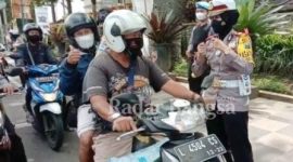 Kasatlantas AKP Indah Citra Fitriani saat memberikan hadiah kepada pengendara yang melintas di Jalan Diponegoro, Kota Batu [ist]