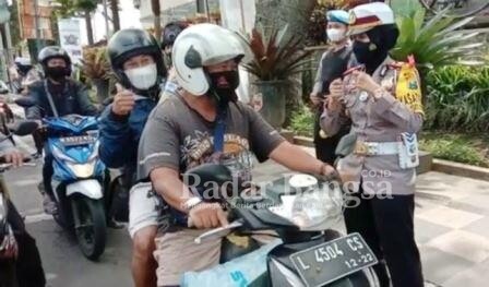 Kasatlantas AKP Indah Citra Fitriani saat memberikan hadiah kepada pengendara yang melintas di Jalan Diponegoro, Kota Batu [ist]