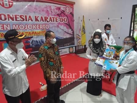 Bupati MOJOKERTO dr. Hj. Ikfina Fahmawati didampingi Kadisparpora H. Amat Susilo,  MM dan Camat Pacet Drs. HM. Malik. Msi saat menyematkan Medali dan Piagam Penghargaan Kepada Atlet Karateka yang membawa Nama Harum Mojokerto [IST]