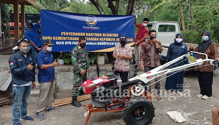 PPL Kec. Mojo, Bidrotin mendorong hand tractor dengan disaksikan oleh Ketua DPD Partai NasDem Kab. Kediri, Drs. H. Lutfi Mahmudiono, Ketua Poktan Tani Makmur Desa Surat, Komarudin, Babinsa Desa Surat, Bidrotin, M. Fadli, dan Ketua DPC Partai NasDem Kec. Mojo, Binti Solikah