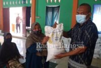 Kepala desa Kertajadi Ade Yuliansyah di wakili sekretaris desa Ujang Sustian sedang menyerahkan Bantuan Sosial Beras (BSB) kepada Keluarga Penerima Manfaat (KPM) dengan prokes super ketat