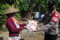 Bhabinkamtibmas desa Gelarwangi/Mekarjaya  Bribka Dede Hidayat di Kampung Cilemo desa Mekarjaya bersama Kapolsek Cidaun, sedang menyerahkan bantuan beras kepada KPM terdampak PPKM Level 4