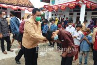 Hambali salah seorang mahasiswa praktek Kuliah Kerja Nyata (KKN) kelompok XI STISIP Syamsul 'Ulum Sukabumi sedang menyerahkan santunan terhadap anak yatim, dan yatim piatu di desa Jayapura serta di ikuti rekan mahasiswa lainnya, juga Camat, Ketua TP PKK kecamatan Cidaun dan Kepala desa Jayapura Solihin
