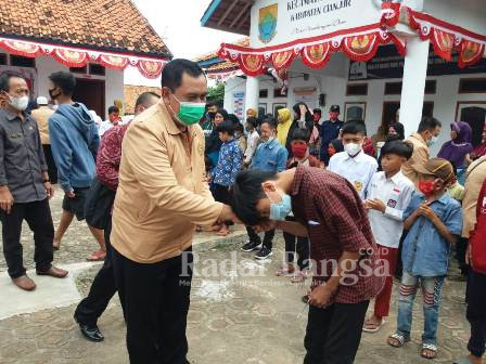 Hambali salah seorang mahasiswa praktek Kuliah Kerja Nyata (KKN) kelompok XI STISIP Syamsul 'Ulum Sukabumi sedang menyerahkan santunan terhadap anak yatim, dan yatim piatu di desa Jayapura serta di ikuti rekan mahasiswa lainnya, juga Camat, Ketua TP PKK kecamatan Cidaun dan Kepala desa Jayapura Solihin
