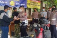 Kasat Lantas polres Pasuruan AKP. Andika Mizal Lubis.S.I.K, bersama kaur Reg Ident IPDA . Moneta Lestari saat memberikan makanan bergizi kepada salah satu wajib pajak