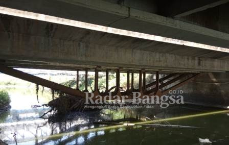 Tampak bawah adanya langganan penumpukan sampah dan puing - puing ranting kayu pada besi penyangga jembatan Plalangan Desa Plosowahyu Lamongan Jawa Timur yang berpotensi banjir saat musim penghujan tiba. Selasa (24/08/2021)