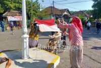 Ibu Sudarti (berkursi roda) khidmat mengibarkan bendera merah putih.