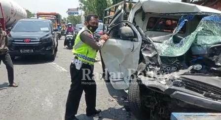 Petugas kepolisian bersama tim medis dibantu oleh pengguna jalan evakuasi korban kecelakaan di ruas jalan nasional Desa Plosowahyu Kecamatan Lamongan. Rabu (29/9/2021).