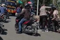 Tangkapan layar video aparat kepolisian memukul mahasiswa yang sedang melakukan aksi demonstrasi