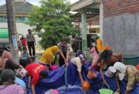 Bhabinkantibmas Polres Lamongan Bripka A. Shandy ikut berjibaku Distribusikan  ribuan air bersih. Senin (25/10/2021)
