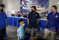 Ketua DPD Partai NasDem Kabupaten Kediri, Drs. H. Lutfi Mahmudiono bersama Bendahara DPD, Vio Debby Saputra, dan Ketua Satgas NasDem Peduli Kabupaten Kediri, Khusnul Arif, S.Sos saat melakukan pengecekan pelaksanaan vaksinasi di Balai Desa Badalpandean