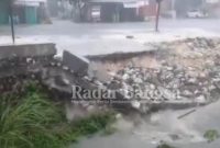 Tembok Penahan Tanah (TPT) yang ambrol tepatnya di depan lapangan desa Sugio Kecamatan Sugio Kabupaten Lamongan. Senin (18/10/2021)