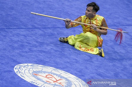 Salah satu atlet wushu Jatim Muhammad Daffa beraksi dalam final Wushu kategori Qiang Shu Putra pada PON Papua di Gor Futsal Dispora, Kabupaten Merauke, Papua, Jumat (1/10/2021). Muhammad Daffa berhasil meraih medali emas pada pertandingan tersebut. ANTARA FOTO/Galih Pradipta/YU. (ANTARA FOTO/GALIH PRADIPTA)
