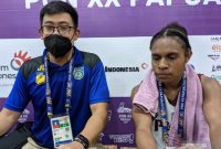 Pelatih tim bola basket putri Papua Jerry Natanael (kiri) dan pemainnya Elizah Baminggen memberikan keterangan kepada media usai laga Pool Y PON XX Papua kontra tuan rumah Sulawesi Selatan di Mimika Sport Complex, Mimika, Minggu (3/10/2021). Papua kalah 45-68 pada pertandingan tersebut. (Michael Siahaan)