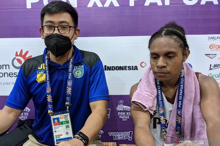 Pelatih tim bola basket putri Papua Jerry Natanael (kiri) dan pemainnya Elizah Baminggen memberikan keterangan kepada media usai laga Pool Y PON XX Papua kontra tuan rumah Sulawesi Selatan di Mimika Sport Complex, Mimika, Minggu (3/10/2021). Papua kalah 45-68 pada pertandingan tersebut. (Michael Siahaan)