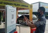 Paur Subbag Humas Polres Lamongan AIPDA Sampurno melakukan scanner di aplikasi pedulilindungi saat memasuki Mapolres. Rabu (27/10/2021)
