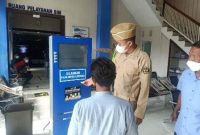 Kasat Lantas Polres Lamongan AKP Aristianto Budi Sutrisno, S.H.,S.I.K.,M.H., saat memberikan petunjuk memilih menu layanan di depan pintu masuk pelayanan SIM bagi masyarakat Lamongan. Rabu, (10/11/2021).