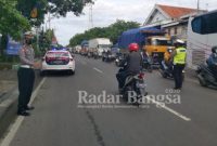 Kasat Lantas Polres Lamongan AKP Aristianto Budi Sutrisno, S.H., S.I.K., M.H., bersama anggota melakukan upaya mengatasi kemacetan yang terjadi sejak tadi malam di Tugu Batik perbatasan Lamongan - Gresik, Dusun Gajah, Simpang 3 Deket, Simpang 3 STM, Bundaran Adipura, Simpang 4 Kaliotik, di Simpang 3 Mawut, Simpang 3 Pos Terminal, Jembatan Balun, dan Desa Karang Langit (Barat Plosowahyu). Senin, 13/12/2021. (Dok Foto: Istimewa Polres Lamongan /RadarBangsa.co.id)