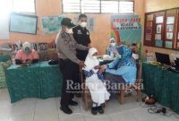 (Baju Hitam) Kanit Reskrim Polsek Tikung Polres Lamongan Ipda Sono, SH bersama anggota melakukan Pendampingan dan monitoring Vaksinasi  di Sekolah Dasar Negeri /MI  Botohputih Kecamatan Tikung Kabupaten Lamongan, Rabu (29/12/2021)