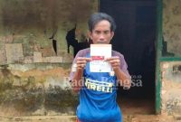 Sarbini warga Desa Batokorogan, Kecamatan Kokop saat menujukan kartu bantuhan dari pemerintah (IST)