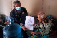 TKSK Kecamatan Pucuk, Ali Fatkurrozi saat salurkan bantuan Air Shodaqoh pada lansia, Jumat (21/01) (Dok Foto Edi S/RadarBangsa.co.id)