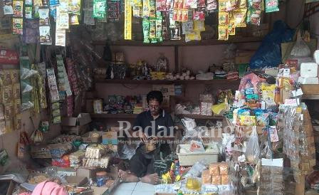 Salah satu pedagang di pasar tradisional Sumlaran yang sepi pembeli, stok minyak goreng di tokonya kosong (IST)