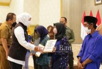 Gubernur Khofifah  menyerahkan santunan kematian kepada 11 ahli waris korban meninggal dunia tragedi laka laut  ritual di Pantai Payangan Jember, Senin (14/2/2022) (IST)