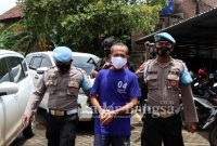 (Tengah) Dukun Cabul saat di kawal anggota Polisi (IST)