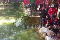  Fujika Senna Oktavia saat menebar benih ikan di telaga Solokuro