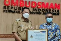 Bupati Lamongan Yuhronur Efendi saat menerima penghargaan kepatuhan pelayanan publik dari Kepala Perwakilan ORI Jatim, Agus Mutaqqin, Senin (31/01) (IST)